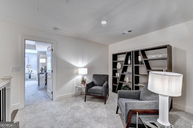 sitting room featuring visible vents, carpet, and baseboards
