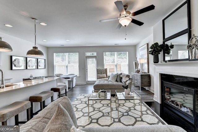 living area featuring dark wood-style flooring, a glass covered fireplace, plenty of natural light, and recessed lighting
