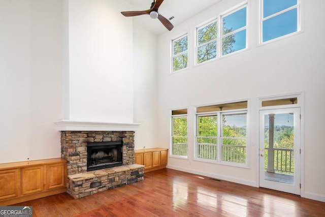 420 Martin Rd, Ellijay, GA 30536 - unfurnished living room with ceiling fan, a stone fireplace, wood finished floors, and a towering ceiling