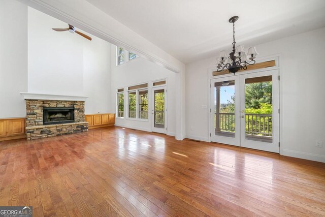 420 Martin Rd, Ellijay, GA 30536 - unfurnished living room featuring a fireplace, baseboards, wood-type flooring, and ceiling fan with notable chandelier