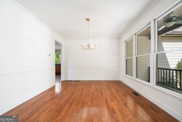 420 Martin Rd, Ellijay, GA 30536 - unfurnished dining area with crown molding, baseboards, an inviting chandelier, and wood finished floors