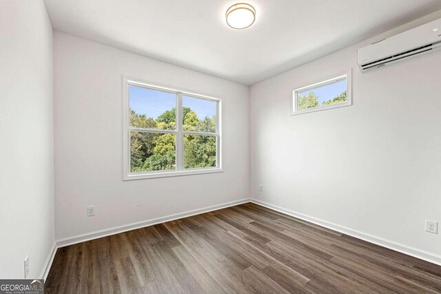 585 Ira St SW, Atlanta, GA 30312 - empty room with an AC wall unit, baseboards, and wood finished floors