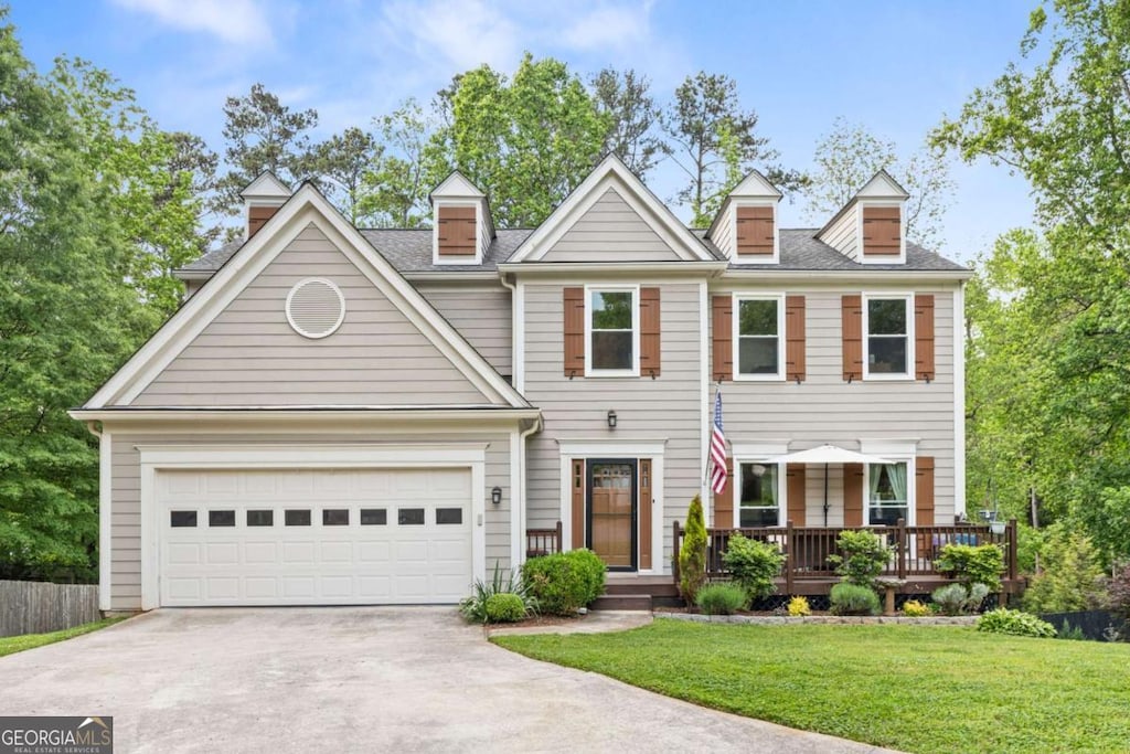 view of front of home with concrete driveway, a garage, and a front lawn