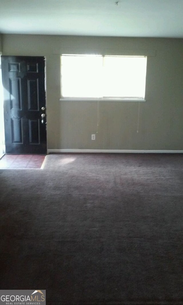 carpeted empty room with baseboards