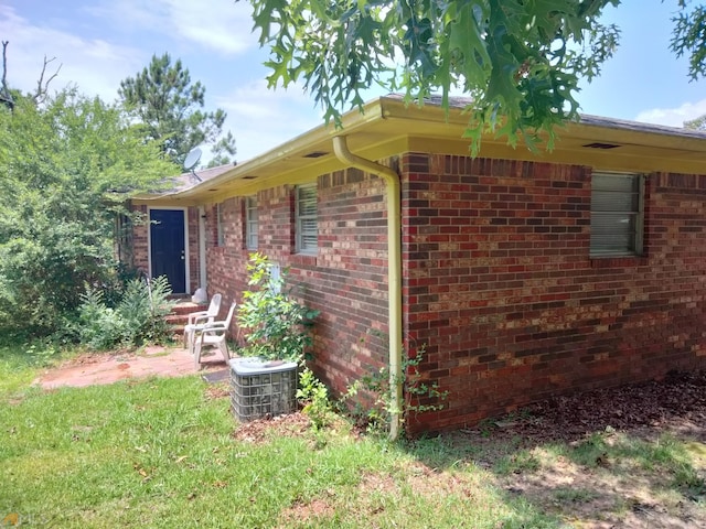exterior space with central AC unit and brick siding