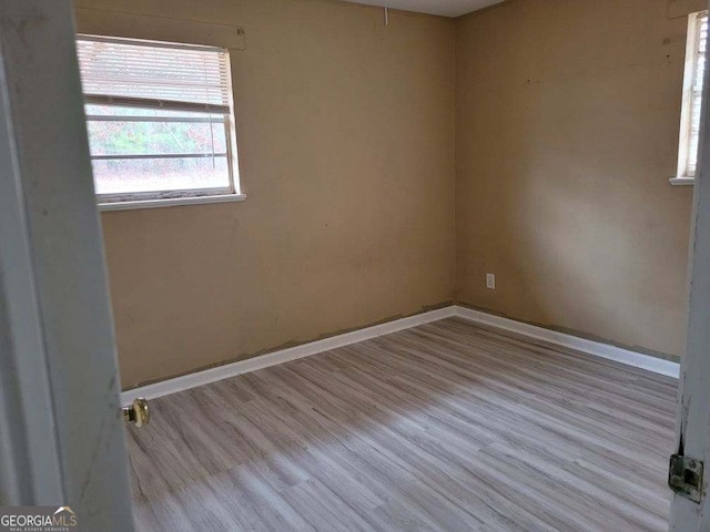 unfurnished room with baseboards and wood finished floors
