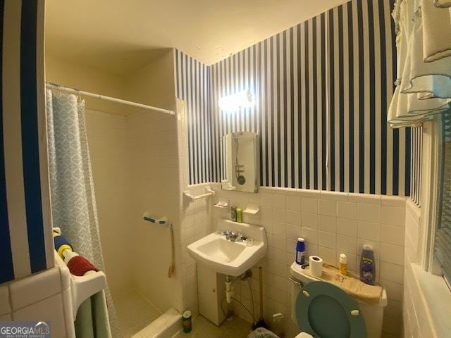 719 N 18th St, Lanett, AL 36863 - full bath featuring wallpapered walls, a shower stall, wainscoting, toilet, and tile walls