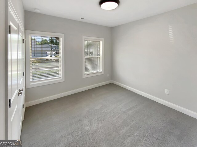 empty room featuring baseboards and carpet