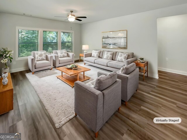 living area with baseboards, ceiling fan, and wood finished floors