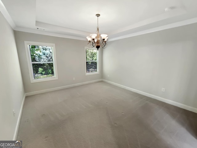 carpeted empty room with an inviting chandelier, a raised ceiling, and baseboards