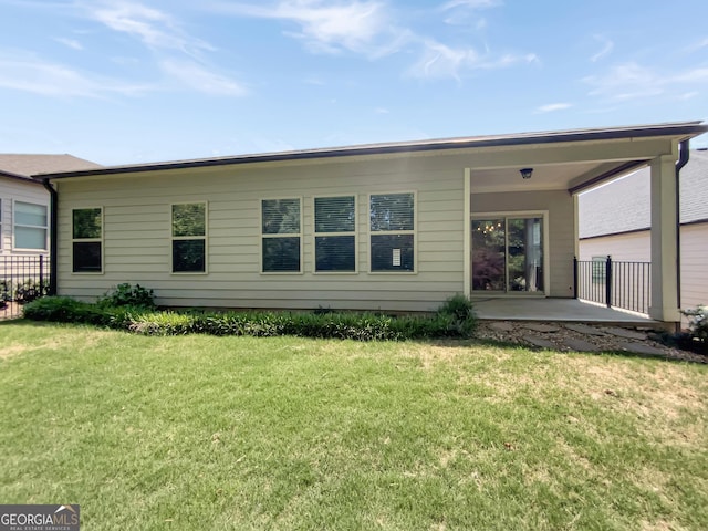rear view of house with a patio and a yard