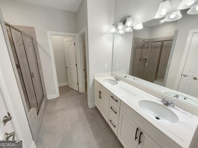 full bathroom with double vanity, a sink, and a stall shower