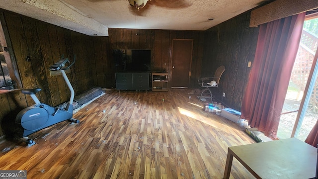 402 Emmett St, Riverdale, GA 30274 - workout room featuring wood walls, a textured ceiling, and wood finished floors