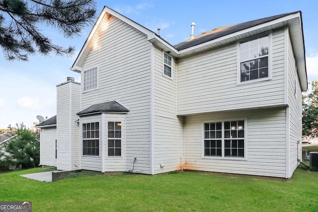 back of house featuring a yard and central AC unit