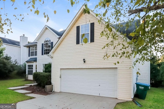 traditional home with driveway, a front yard, and a garage