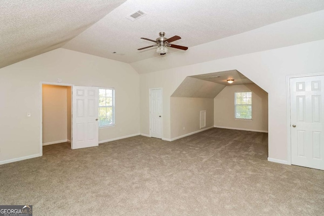 bonus room featuring plenty of natural light, carpet, ceiling fan, and vaulted ceiling