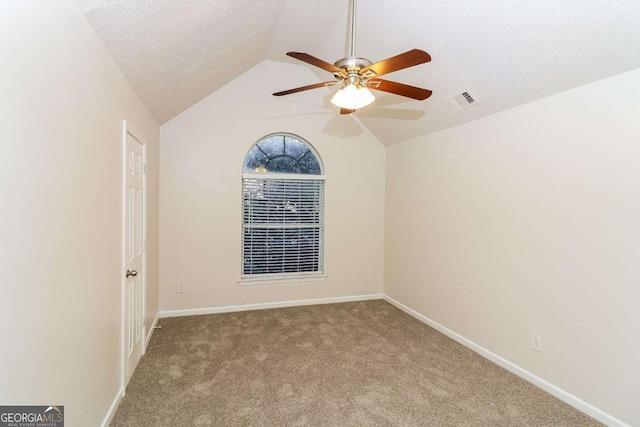 unfurnished room with visible vents, lofted ceiling, baseboards, a ceiling fan, and carpet