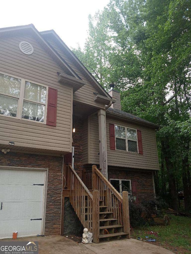 143 Delane Dr, Dallas, GA 30157 - view of front of house featuring a chimney, stairs, stone siding, and a garage