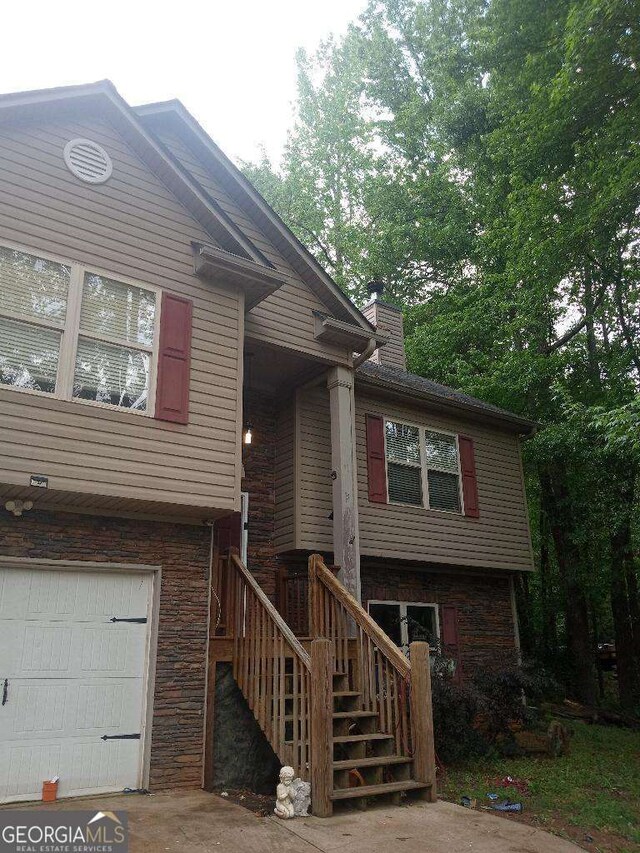 143 Delane Dr, Dallas, GA 30157 - view of front of house featuring a chimney, stairs, stone siding, and a garage