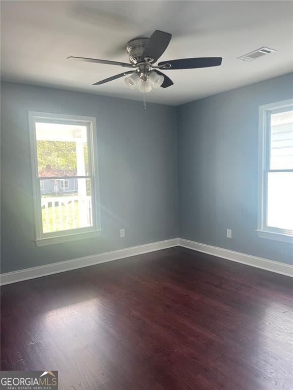 unfurnished room with dark wood-type flooring, baseboards, and ceiling fan