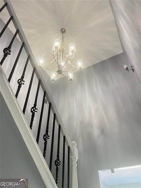 stairs featuring a chandelier