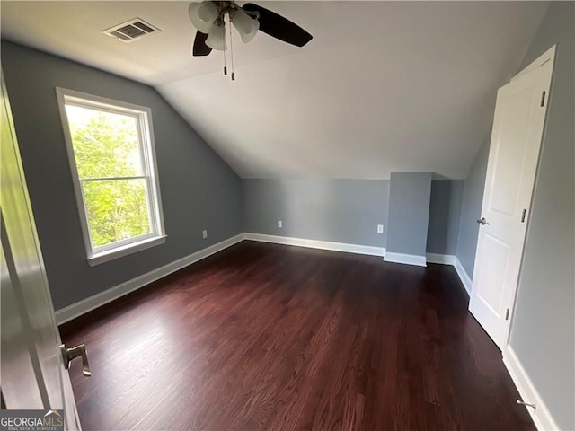 bonus room featuring lofted ceiling, a ceiling fan, dark wood-style flooring, and baseboards