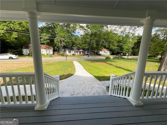 deck featuring a porch and a yard