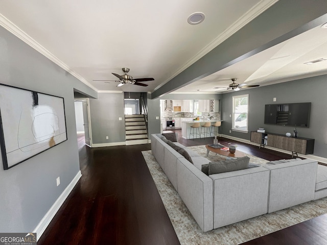 living room with baseboards, wood finished floors, stairway, ornamental molding, and ceiling fan
