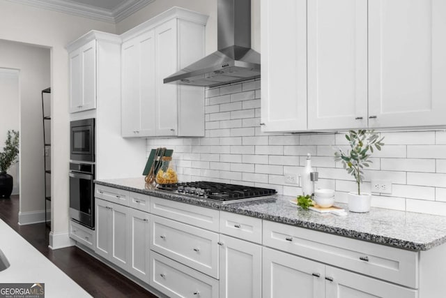 kitchen with white cabinets, light stone countertops, stainless steel appliances, and wall chimney exhaust hood