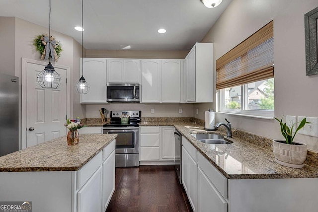 kitchen featuring a sink, appliances with stainless steel finishes, dark wood-style floors, and light stone countertops