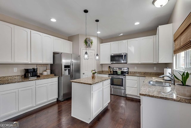 kitchen featuring a sink, light stone countertops, stainless steel appliances, and white cabinetry