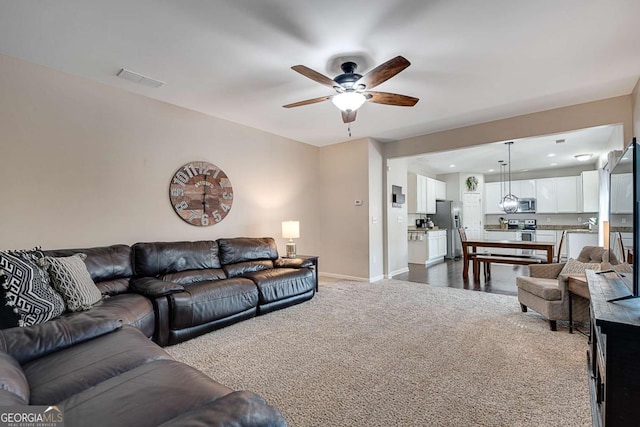 living room with ceiling fan, visible vents, baseboards, recessed lighting, and dark carpet