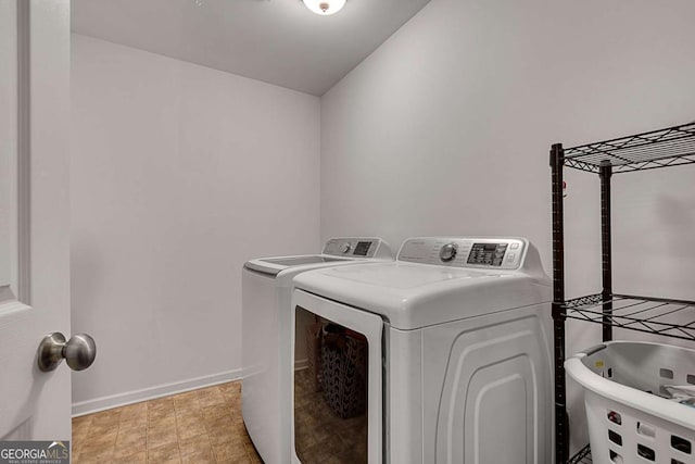 clothes washing area with washer and dryer, laundry area, a sink, and baseboards