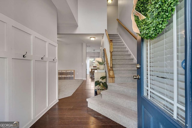 entryway with baseboards, stairway, and dark wood-type flooring