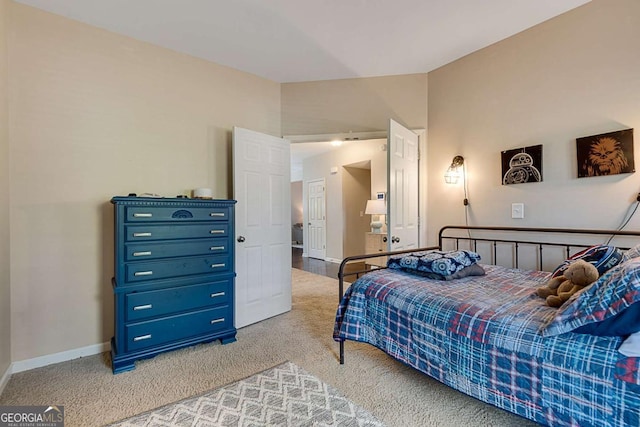 bedroom with baseboards, lofted ceiling, and light carpet