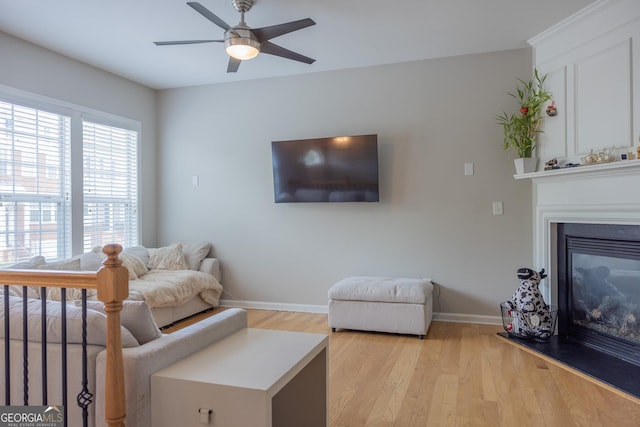1306 Thornborough Dr Unit 1306, Alpharetta, GA 30004 - living area with light wood finished floors, ceiling fan, baseboards, and a glass covered fireplace