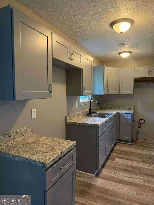 184 Quail Rd, Griffin, GA 30223 - kitchen with a textured ceiling, visible vents, a sink, and wood finished floors