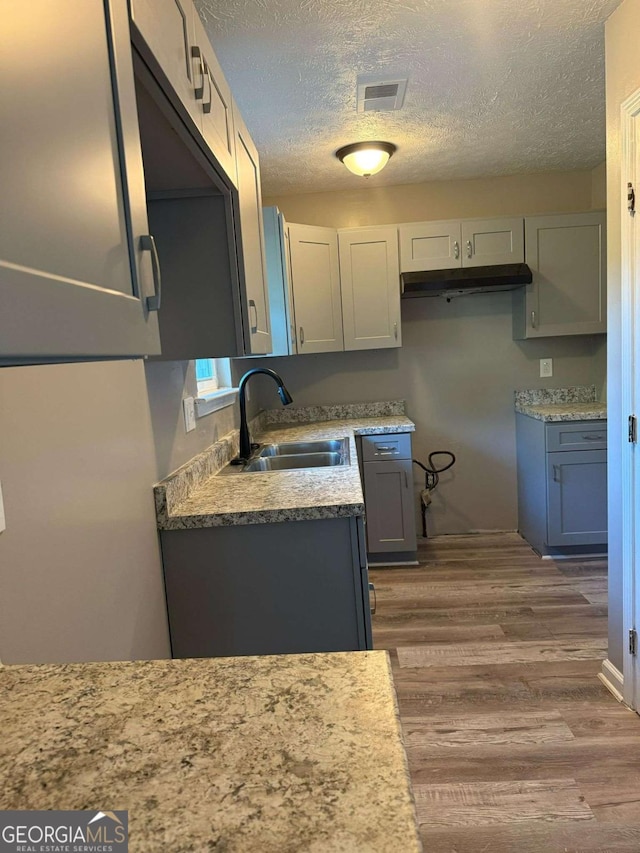 184 Quail Rd, Griffin, GA 30223 - kitchen with a sink, light countertops, a textured ceiling, visible vents, and dark wood-style floors