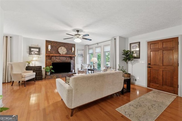1149 Midland NW, Acworth, GA 30102 - living area with ceiling fan, a stone fireplace, light wood-style floors, and a textured ceiling