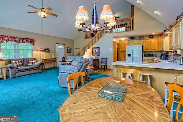 dining area with stairway, high vaulted ceiling, and ceiling fan with notable chandelier