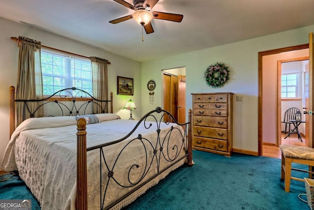 bedroom with carpet flooring, ceiling fan, multiple windows, and a closet
