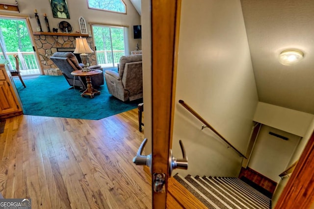 staircase with lofted ceiling and wood finished floors