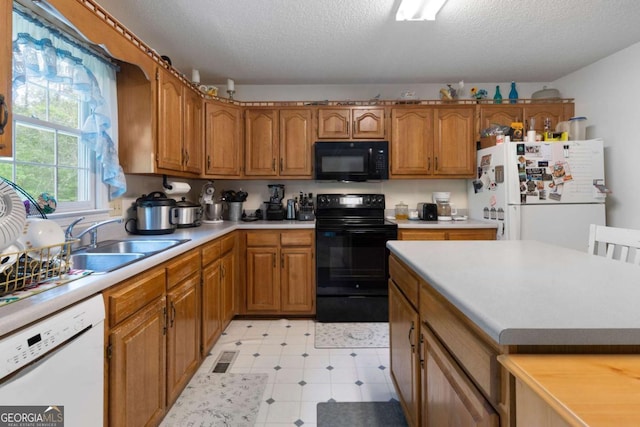 569 Hale Mountain Ct, Hiram, GA 30141 - kitchen featuring brown cabinets, a sink, light countertops, black appliances, and light floors