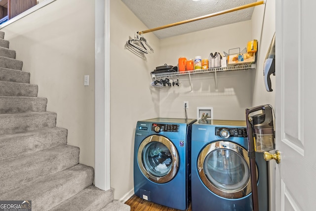washroom featuring independent washer and dryer, laundry area, a textured ceiling, baseboards, and wood finished floors