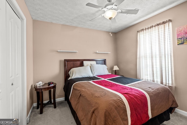bedroom featuring baseboards, carpet, a closet, and a textured ceiling
