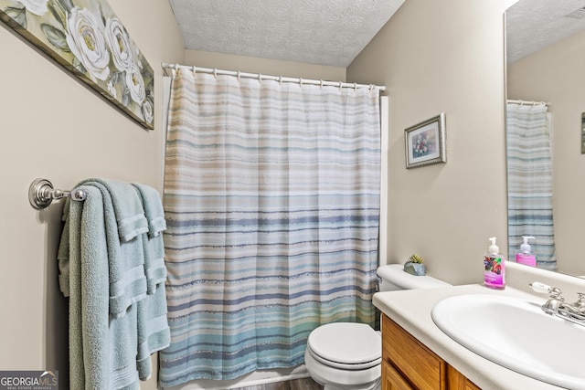 bathroom featuring toilet, a textured ceiling, curtained shower, and vanity