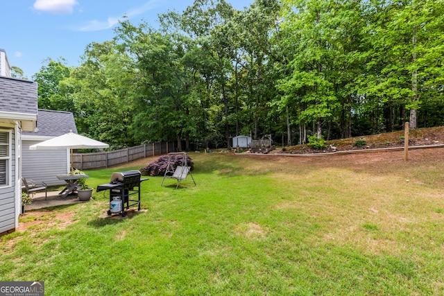 view of yard with a storage unit, fence, and an outbuilding