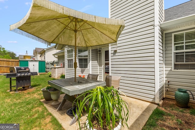 exterior space with fence, roof with shingles, a storage unit, an outbuilding, and outdoor dining space