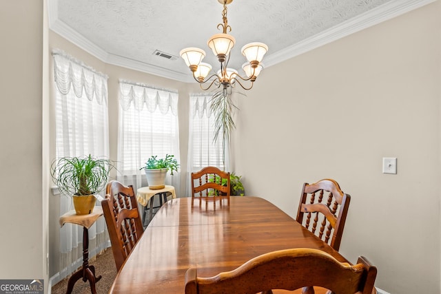 dining area with visible vents, ornamental molding, a textured ceiling, and a notable chandelier
