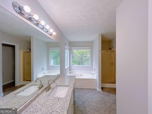 bathroom featuring a garden tub, a textured ceiling, vanity, and a shower stall